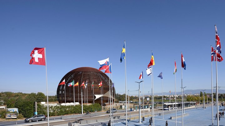 Globe of Science and Innovation am CERN | Bildquelle: Rachel Lavy/Julien Ordan/Maximilien Brice/CERN Die Flaggen der Mitgliedstaaten flattern vor dem Kugelhausbau am CERN im Wind. Der Himmel ist wolkenlos.
